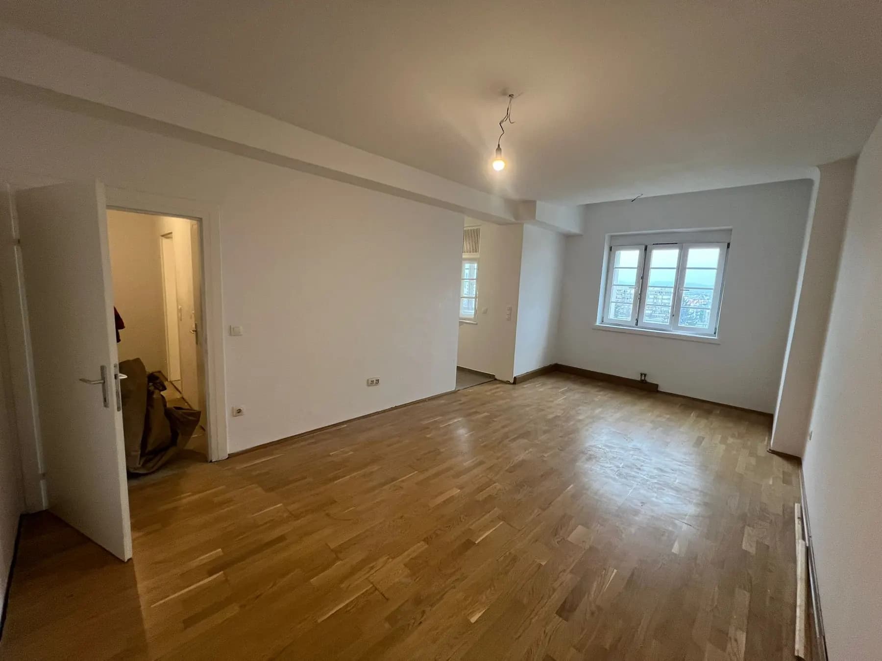 Leerer Wohnraum mit Parkettboden, Wände und Decke frisch weiß gestrichen